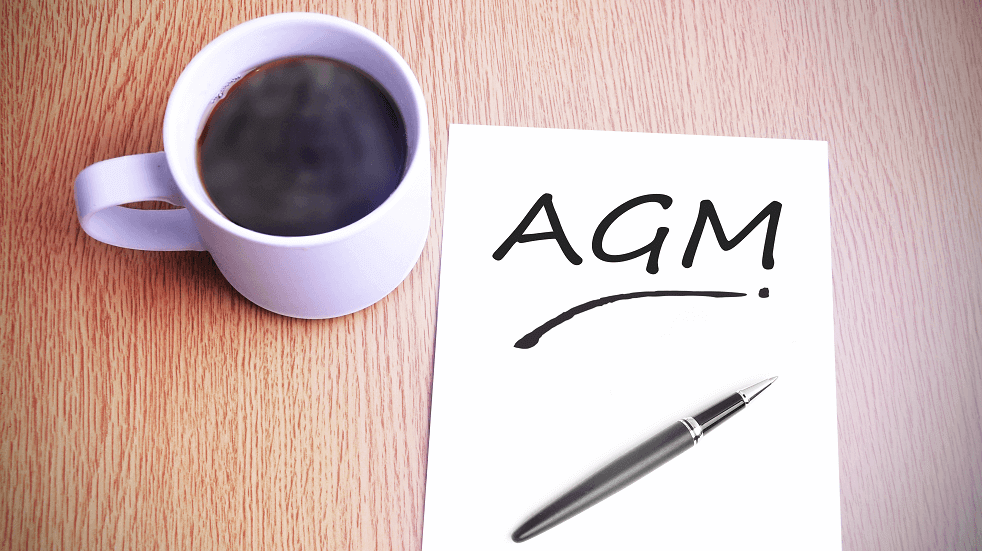 AGM with a cup of coffee pen paper table